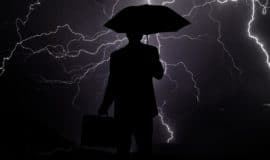 person with umbrella in lightening storm