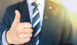 man in suit doing thumbs up